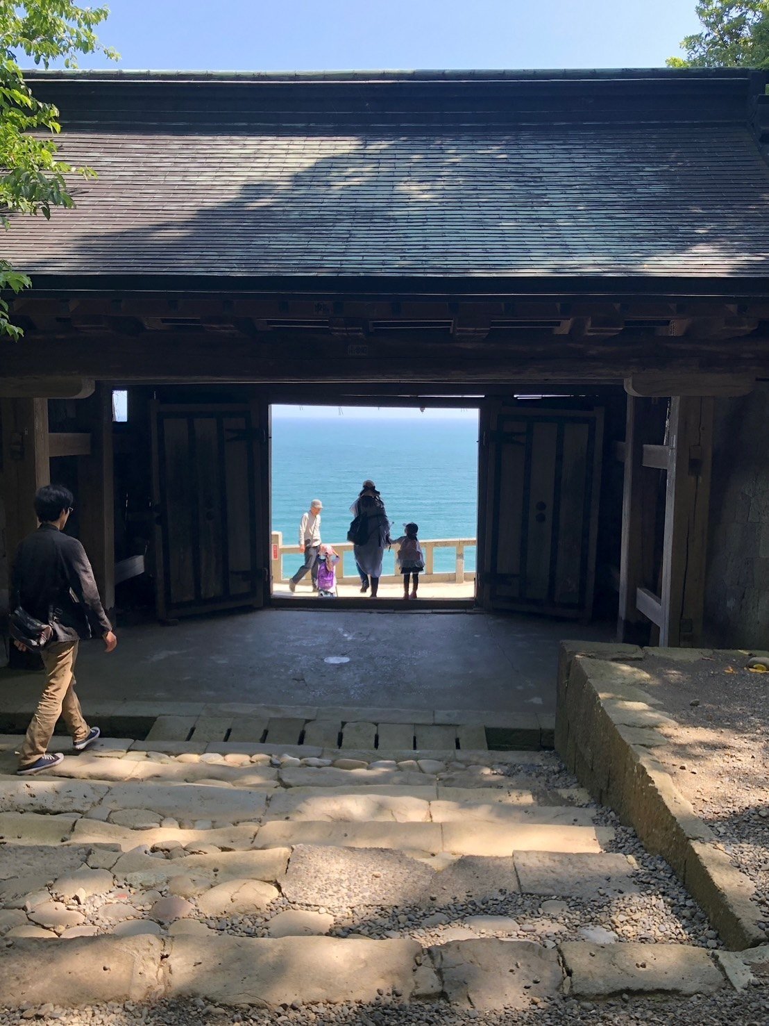 伝統的な門の向こうに海が見える風景。撮影：Taka